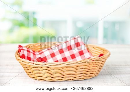 Wicker Basket With A Red Cloth Napkin Inside On A Wooden Table