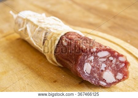 Piece Of Spanish Salami Fuet On A Wooden Chopping Board