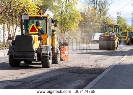Tractor With Spinning Brush Cleaning Newly Laid Asphalt. Reconstruction And Repair Of A Street Road,