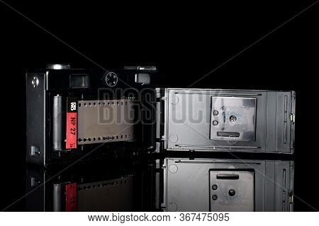 One Whole Opened Vintage Camera Isolated On Black Glass