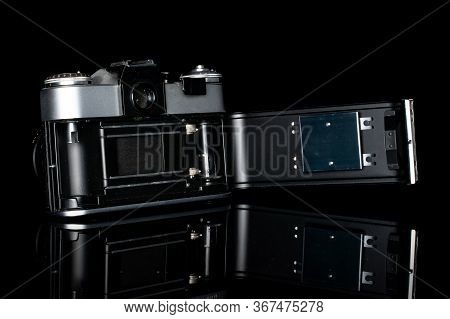 One Whole Opened Vintage Camera Isolated On Black Glass