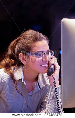 Woman Answers Customer Calls In A Call Center. The Secretary Answers The Phone And Talks With Client