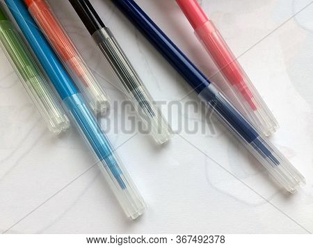 Multi-colored Felt-tip Pens Lie On A White Paper Close-up