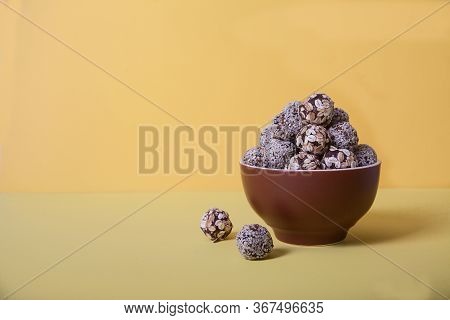 Energy Balls Of Dried Fruits And Nuts Sprinkled With Sesame And Granola Lie On A Blue Porcelain Plat