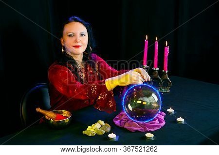 A Young Clairvoyant And Fortuneteller Reads The Future On A Mirror Ball In A Magic Salon On A Black 
