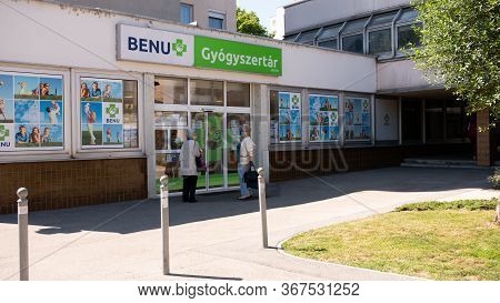 Gyor Hungary 05 21 2020: Elderly Female Customers Are Waiting At The Entrance Of A Benu Pharmacy In 