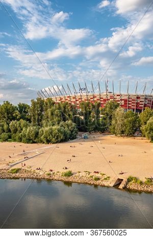 Warsaw, Poland - April 19, 2019: View of the National Stadium and public beach at Vistula river at spring in Warsaw