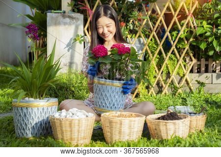 Asian Woman Plant A Flower In Her Garden, This Image Can Use For Home, Flower, Gardent And Environme