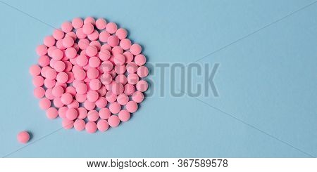 Pile Of Pink Pills On A Blue Background In The Form Of A Circle