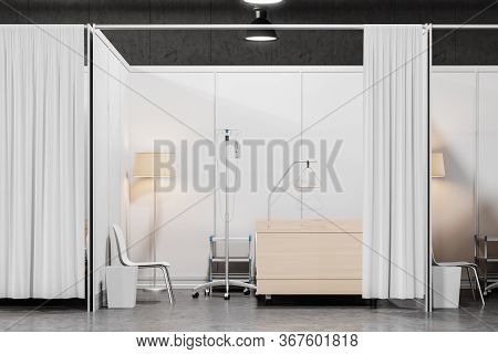 Front View Of Comfortable Empty Bed, Table And Chair In Modern Hospital Ward With White Walls, Concr