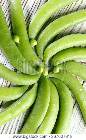 Food Background. Green Pea Pods On A Wooden Table Folded In A Circle. Texture Of Green Pea Pod. Top 