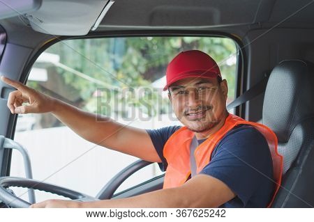 An Asian Man Was Smiling Happily At The Yellow Truck. He Has A Career As A Transport Driver. The Tra