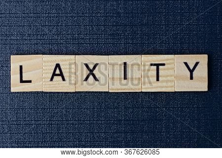 Text On Word Laxity From Gray Wooden Letters On A Black Table