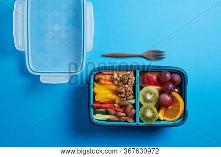 Top View of Full Lunch Box with Fuits, Vegetables and nuts.