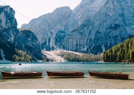 Empty Wooden Boats Moored On The Lago Di Braies On The Background Of Rocky Mountains And Forest. Bra