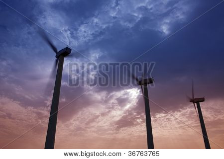 Aerogenerator mulini a vento in energia elettrica cielo drammatico tramonto verde