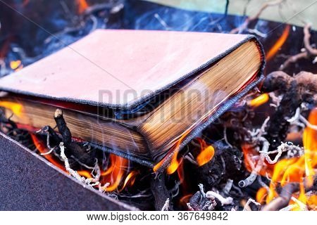 A Thick Book On Fire. Burning Books. Destruction Of Banned Books.