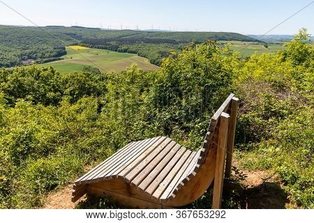 Scenic View From The Lemberg At Landscape With  Wooden Relaxing Bench In The Foreground