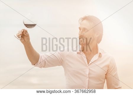 Handsome Man Is Going To Taste Luxury Red Wine. Sommelier With A Glass Of Expensive Wine Smiling Out