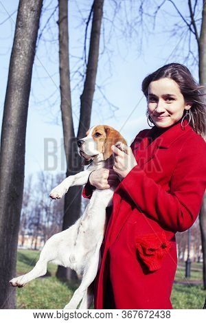 Pretty Young Girl In Redd Coat Playing With Dog Outside In Green Park, Lifestyle People Concept