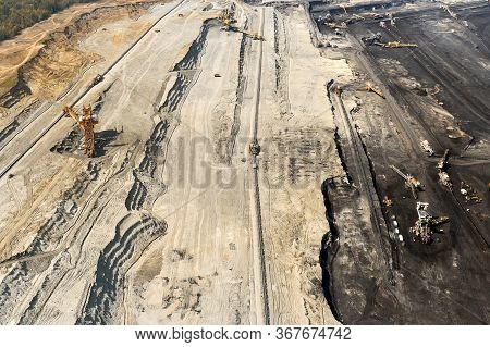 Top View Of A Mining Quarry With Huge Equipment For Coal Or Natural Raw Material Mining. Working Buc