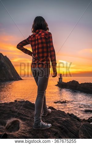 A Young Woman In A Plaid Shirt The Beautiful Lighthouse Of Pasajes San Juan, Near San Sebastian, Gip