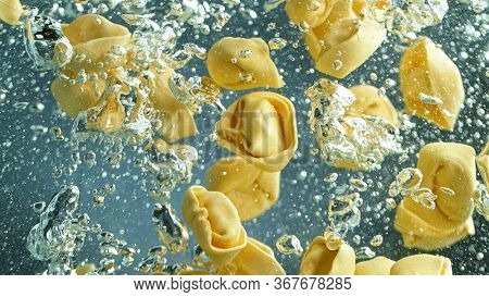 Throwing pasta into boiled water in pot shooting with high speed cinematic camera at 1000 fps.
