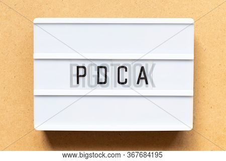 Lightbox With Word Pdca (business Abbreviation Of Plan Do Check Act) On Wood Background