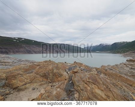 Stony Cliff And Austerdalsvatnet Lake Landscapes Near European Svartisen Glacier In Nordland County 