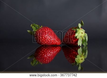 Strawberries On A Black Background With Reflection
