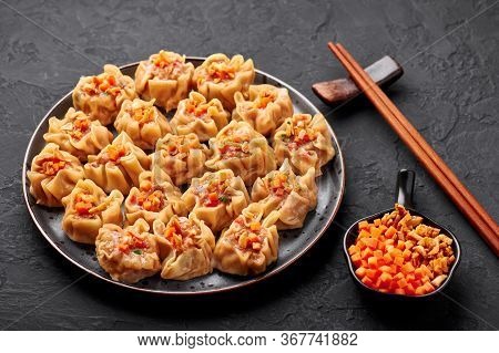 Shumai Or Kanom Jeeb Or Steamed Pork And Shrimp Dumplings On A Black Plate On Dark Slate Backdrop. S