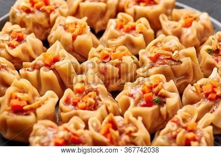 Shumai Or Kanom Jeeb Or Steamed Pork And Shrimp Dumplings On A Black Plate On Dark Slate Backdrop. S