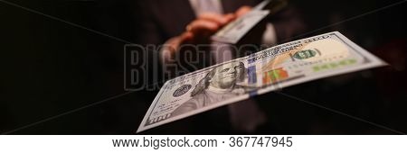 Man In Business Suit Litter Money, Dollars Closeup. Person Spends Thoughtlessly Money On Gambling An