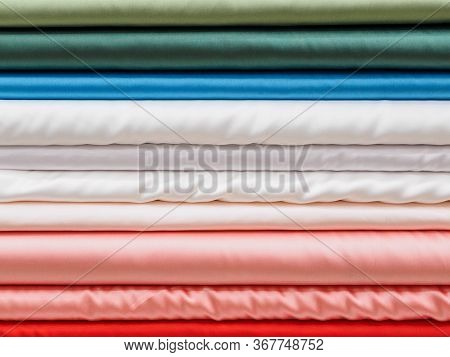 Samples Of Colored Satin Fabrics Close-up. Large Assortment Of Bright Fabrics In The Store. A Tailor