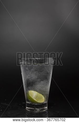 Soad Water In Glass With Lime On Black Background. Cool Soda Water And Lime With Copy Space.