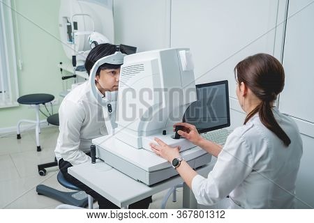 Consultation With An Ophthalmologist. Young Asian Man And Woman Doctor