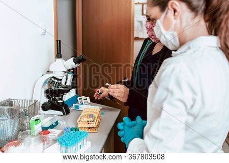 Working In The Lab, Professor Teaching Student About Using Micropipette