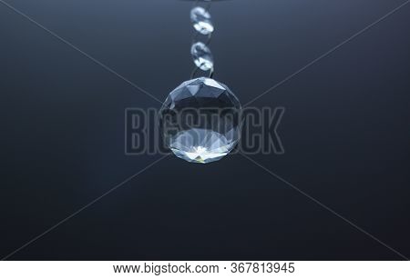 One Crystal From A Lamp On The Ceiling Is In The Air With  A Deep Shades