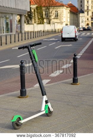Electric Scooter Parked On The Road. Modern Eco Electric City Scooters For Rent Outdoors On The Side