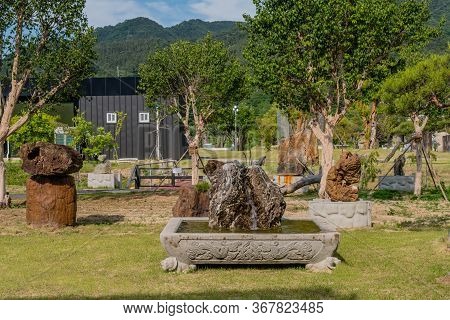 Gimcheon, South Korea; May 24, 2020: Water Fountain Inside Large Hollowed Boulder In Public Rock Gar