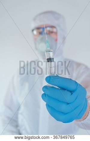 Vaccination Of The Population. Viral Disease Concept.infectionist Doctor In A Protective Suit In Blu