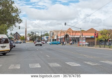 Harrismith, South Africa - March 16, 2020:  A Street Scene, With Businesses, Vehicles, People And A 