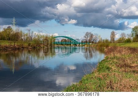 Olse River With Railway Bridge Over In Karvina City In Czech Republic During Springtime Day With Blu