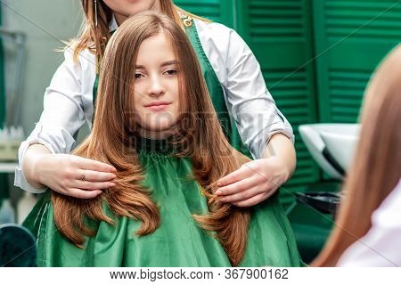 Hairdresser Makes Hairstyle For Beautiful Woman While Looking In The Mirror Reflaction At The Beauty