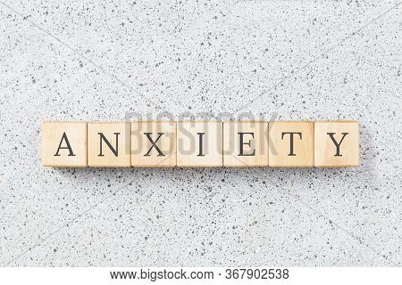 Anxiety Word Made With Wooden Buildning Blocks On Grey Cork Background. Uncertainty And Panic Concep