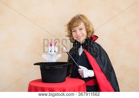 Child Magician Holding A Top Hat With Toy Rabbit