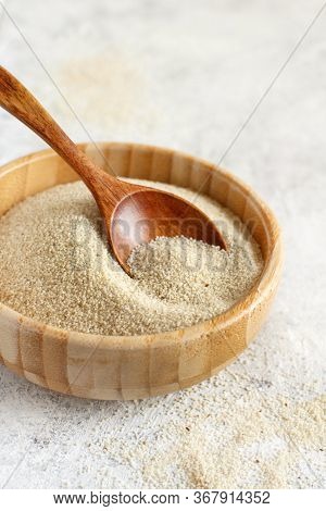 Raw Uncooked Fonio Seeds In A Bowl With A Spoon On Grey Background Close Up With Copy Space