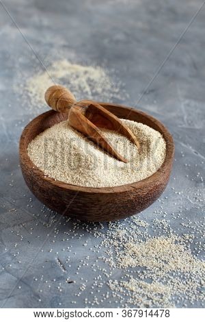 Raw Uncooked Fonio Seeds In A Bowl With A Spoon On Grey Background With Copy Space