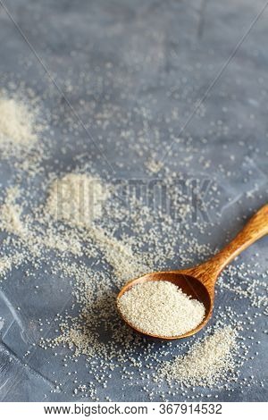 Raw Uncooked Fonio Seeds With A Spoon On Grey Background Close Up With Copy Space