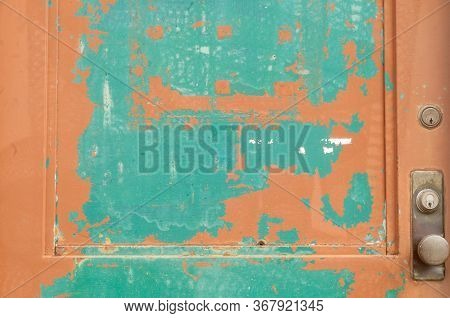 Detail Of An Old Door On A Factory Or Warehouse Showing Two Layers Of Paint That Are Peeling Away; U